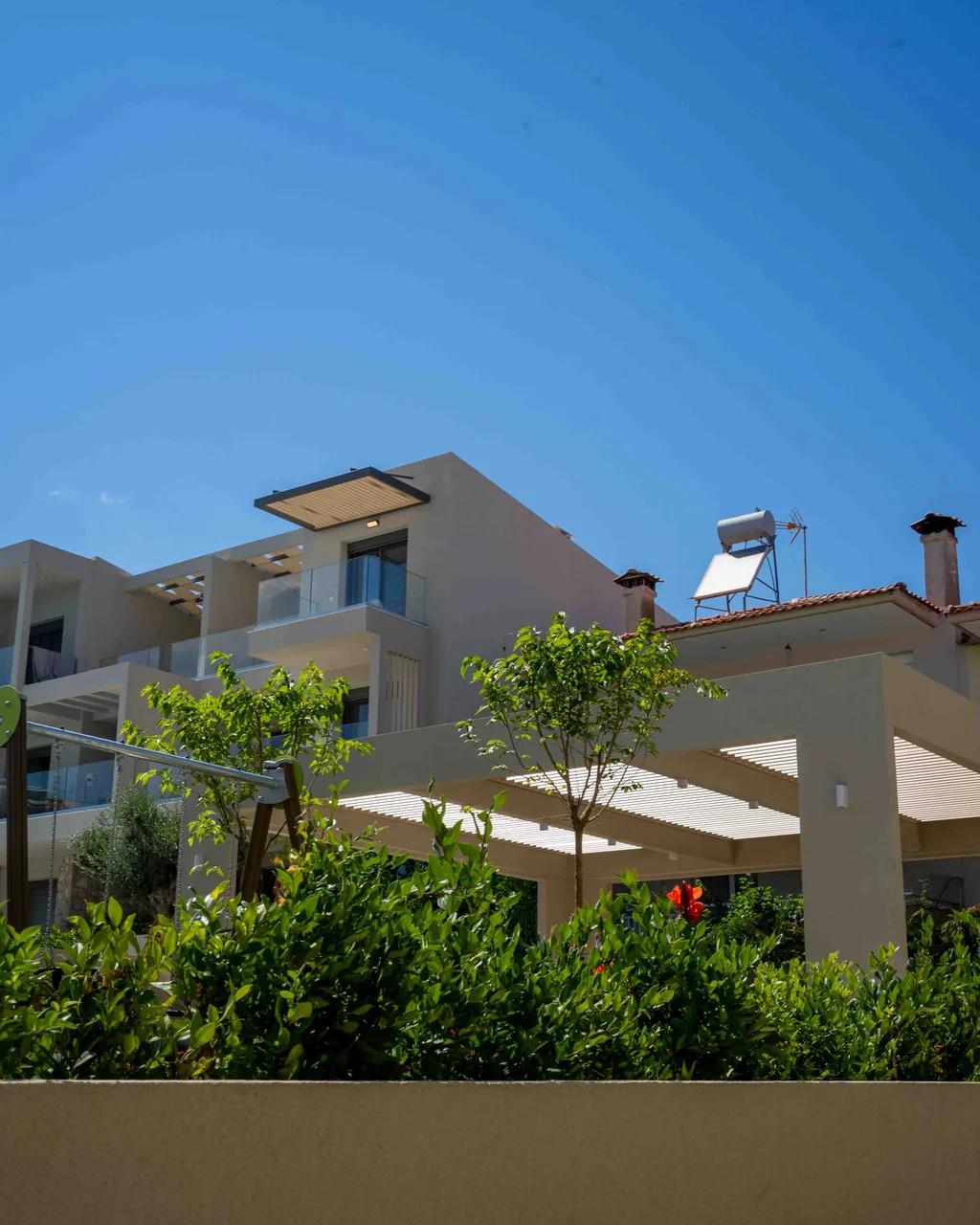 Gebäude der Anlage Orphia mit Pergola und mediterraner Bepflanzung